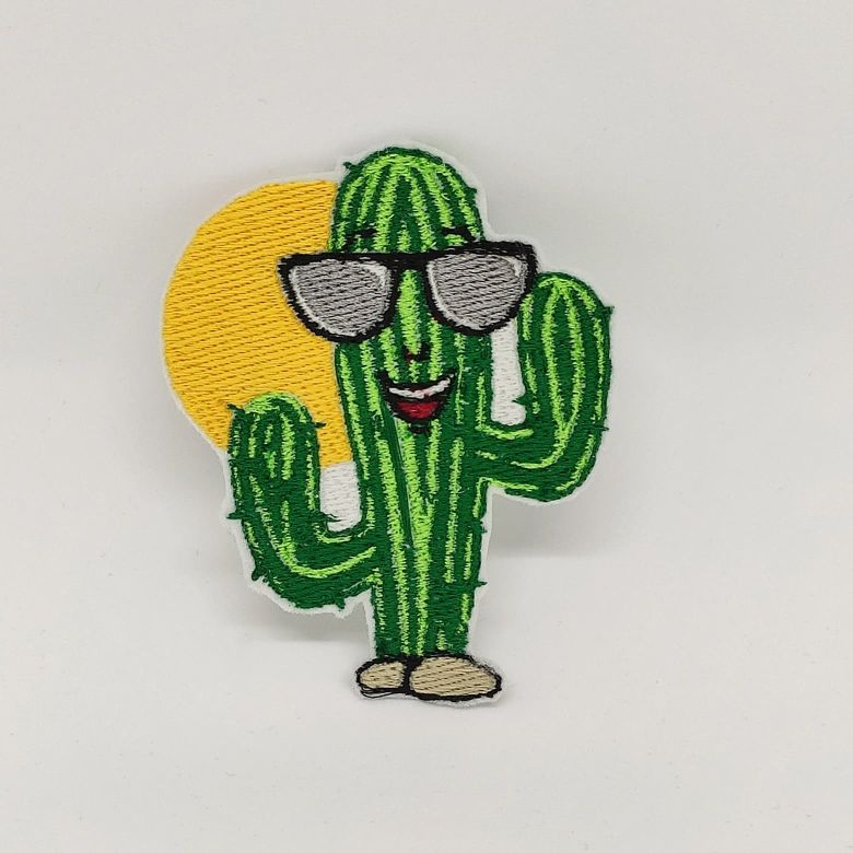 Fotografia di una toppa ricamata a forma di cactus con gli occhiali da sole su sfondo bianco