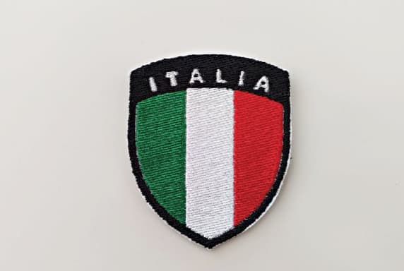 Patch ricamata della bandiera dell'Italia a forma di scudetto con scritto in alto "Italia" colore bianco su nero