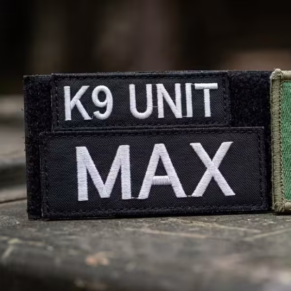 Fotografia di tre patch ricamate su twill. Le due a sinistra sono nere con scritto "K9 Unit" e "MAX" in bianco, mentre l'altra è un tricolore italiano con un simbolo dei paracadutisti.